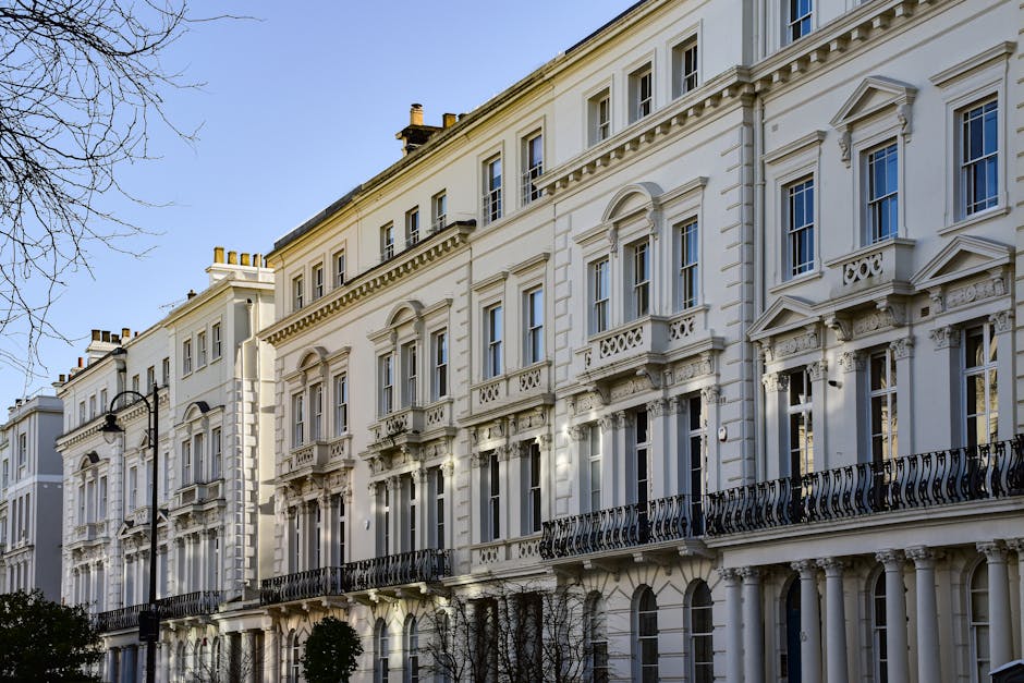 A historic red brick residential building in Soho W1D featuring ornate architectural details, large bay windows with white trim, and decorative stone embellishments near the roofline. The building has